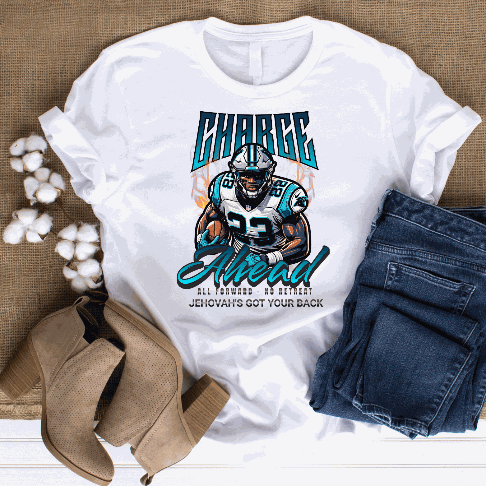 White Charge Ahead Unisex softstyle T-shirt with football player graphic and motivational text, paired with folded jeans and brown ankle boots on burlap background